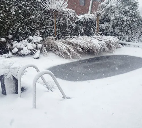 Afgedekt zwembad in de sneeuw